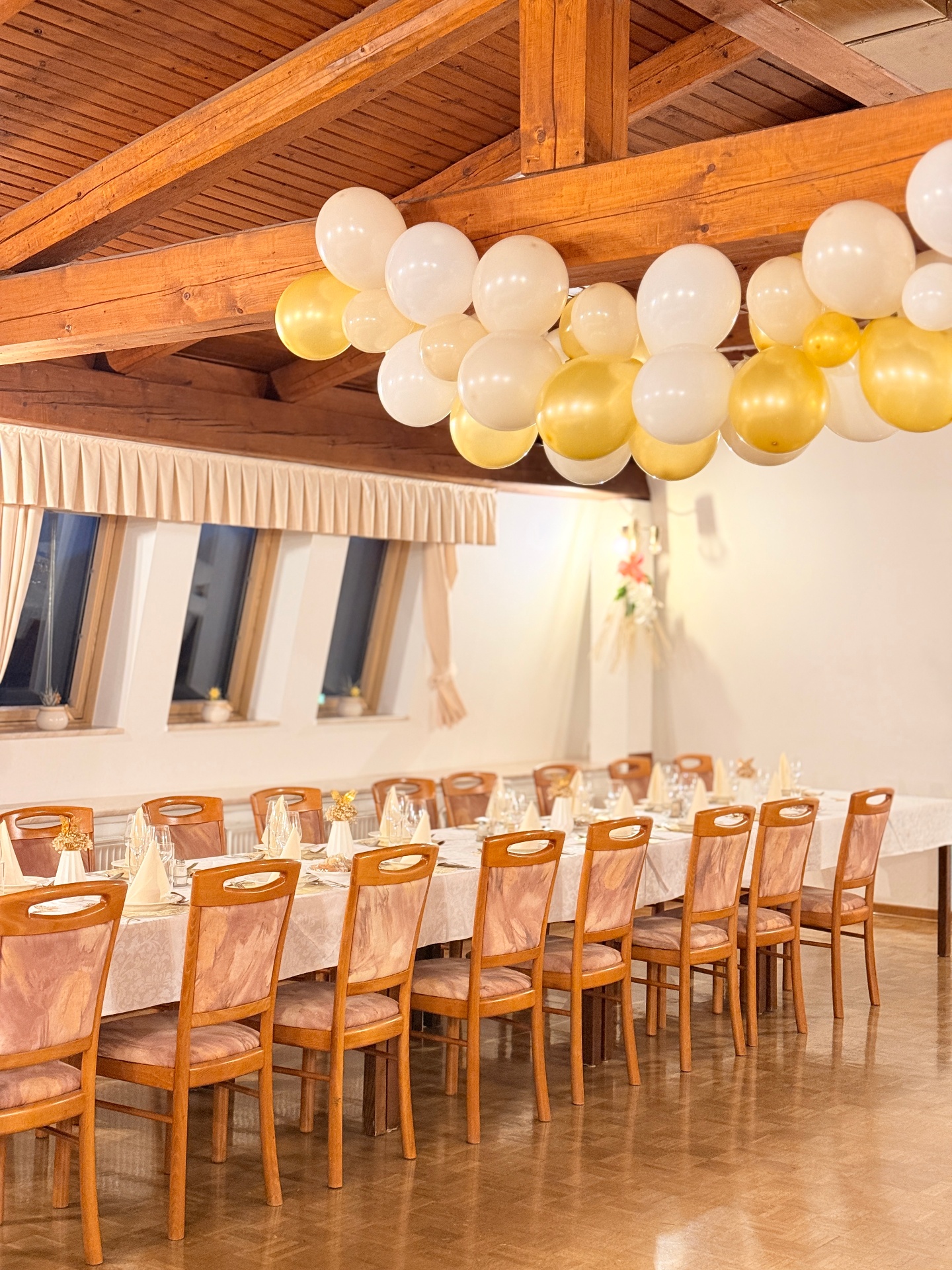 Dvorana z balonsko dekoracijo in pogrnjeno mizo